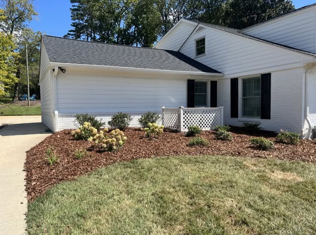 White house with fresh mulch landscaping and black shutters
