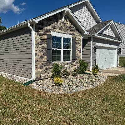 Gray suburban house with stone facade and white garage