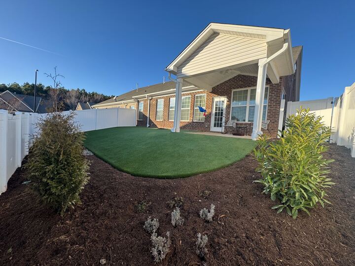 Brick home patio with covered porch and landscaped backyard