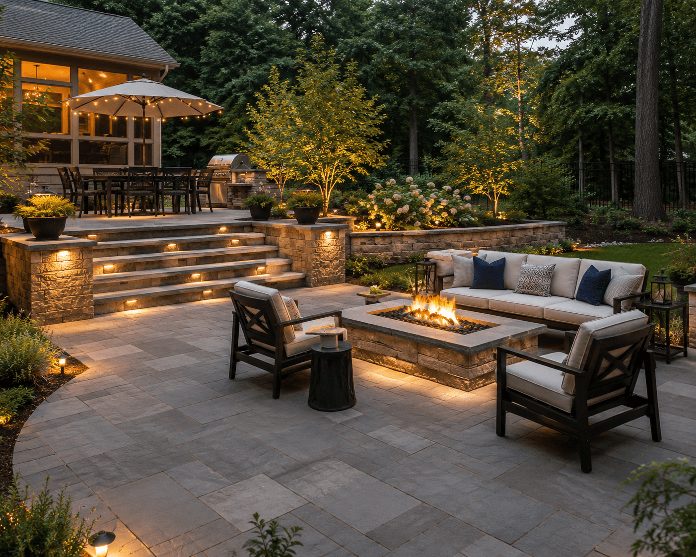 Elegant backyard patio with fire pit and illuminated landscaping
