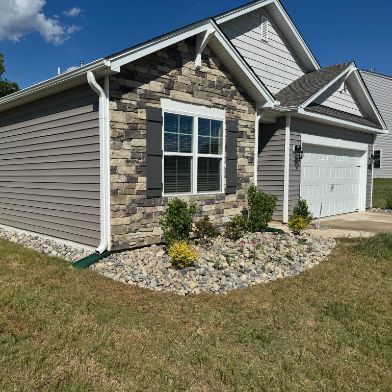 Gray suburban house with stone facade and landscaped garden