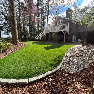 Landscaped backyard with artificial turf and raised deck