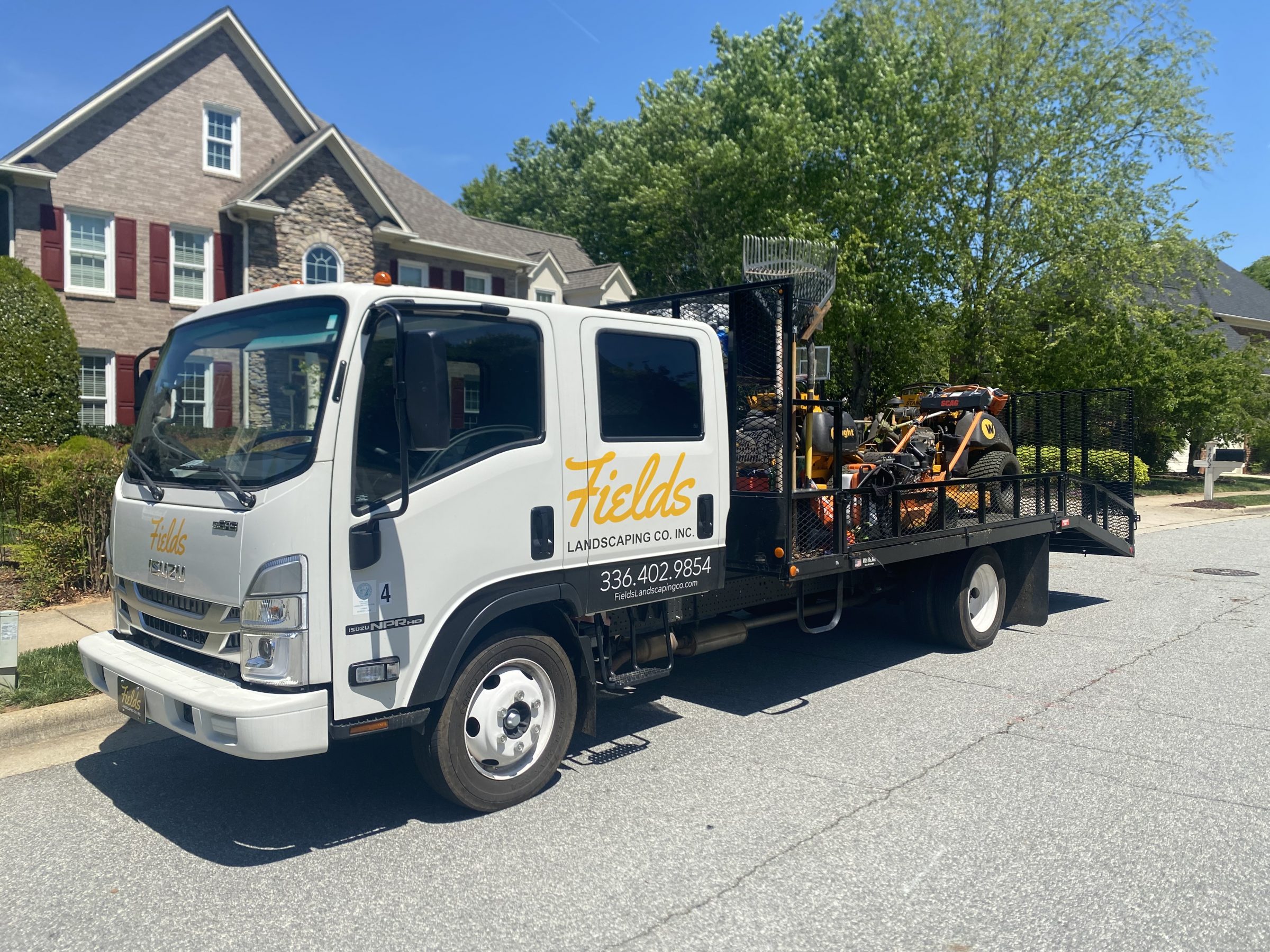 Fields Landscaping truck parked outside a suburban home
