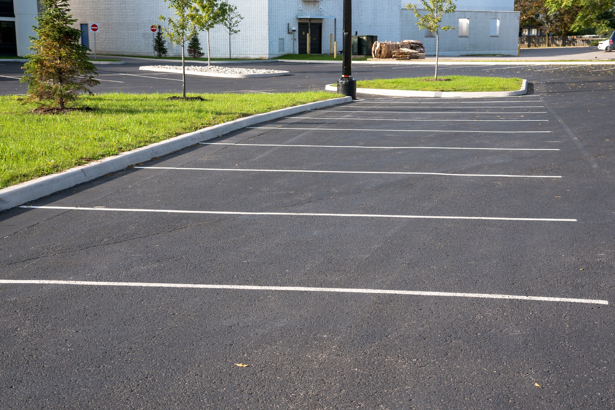 Empty paved parking lot beside landscaped islands