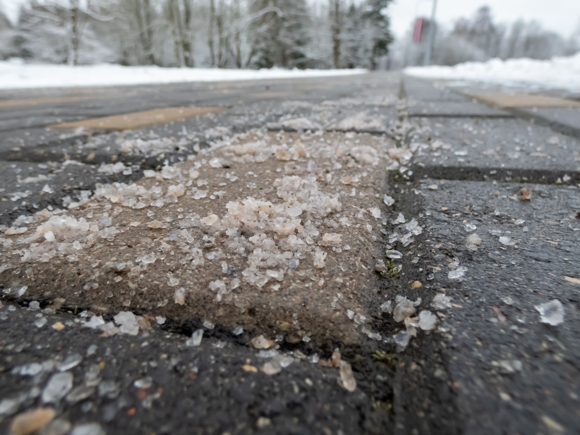 Ice and road salt on snowy sidewalk
