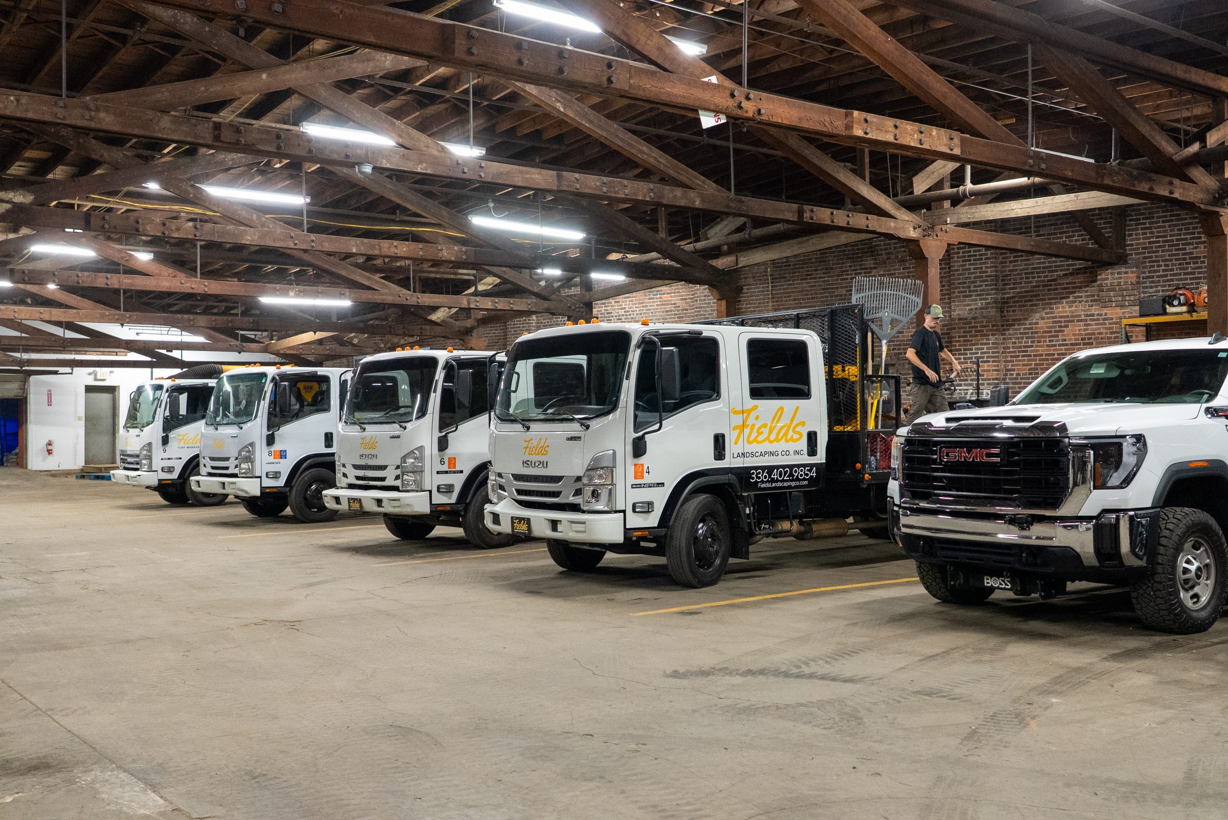 Fields Landscaping trucks parked inside a warehouse garage